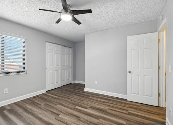 A room with a ceiling fan and two doors.