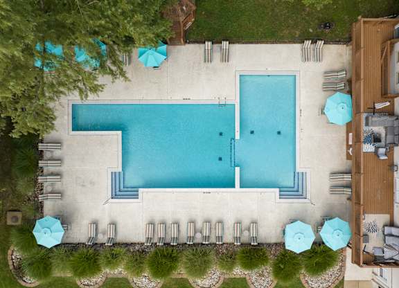A large swimming pool surrounded by lounge chairs and umbrellas.