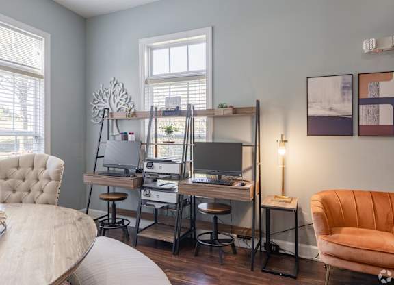 A room with a desk, chair, and a lamp.