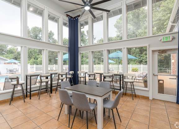 A dining room with a table and chairs and a ceiling fan.