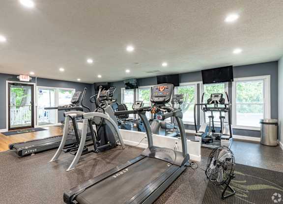 A gym with treadmills, elliptical machines, and other exercise equipment.
