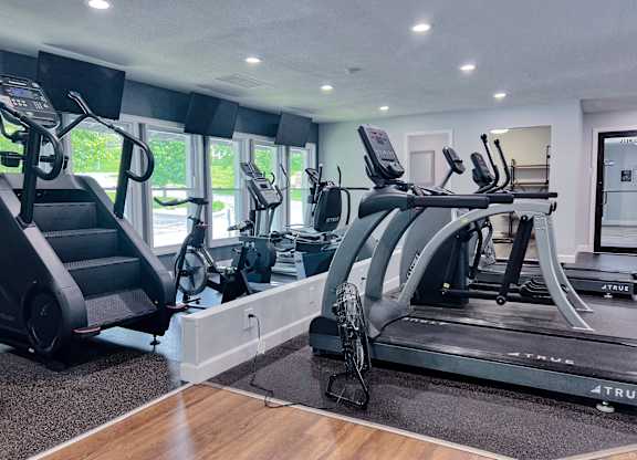 A gym with treadmills, elliptical machines, and a stair climber.