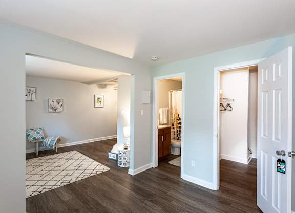 A living room with a white door and a white sofa.