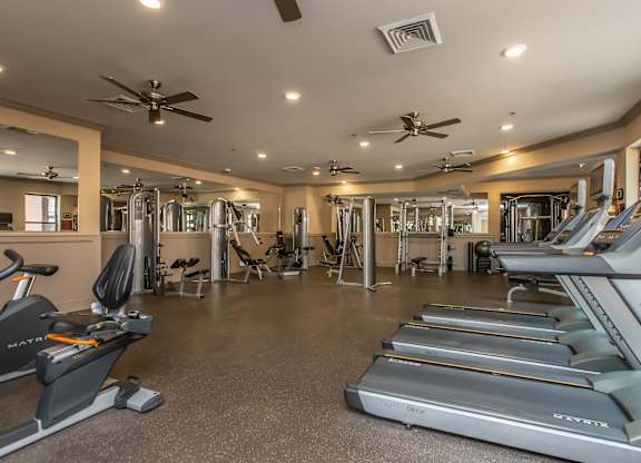 A gym with treadmills, exercise bikes, and other equipment.