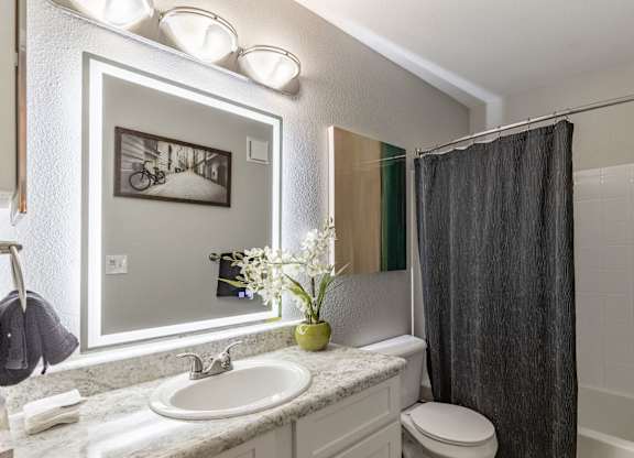 A bathroom with a white sink and a black shower curtain.