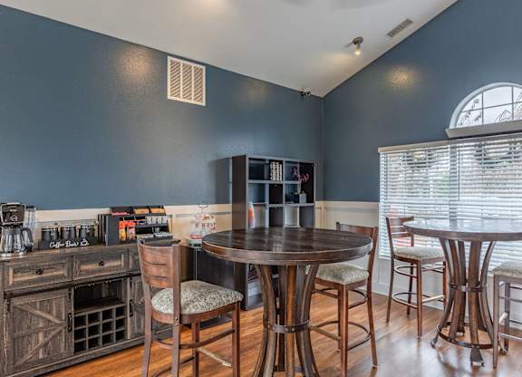 A kitchen with a wooden table and chairs.