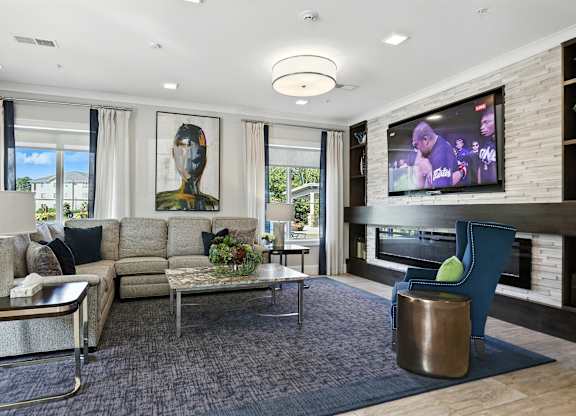 A modern living room with a large screen TV and comfortable seating.