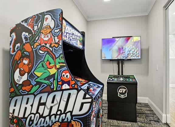 A small indoor play area with a TV and a large arcade machine.