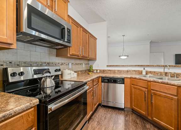 A kitchen with wooden cabinets and a black stove top oven.