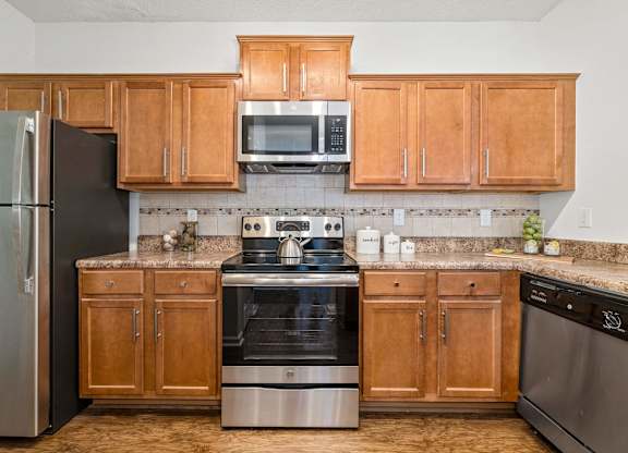 A kitchen with wooden cabinets and stainless steel appliances.