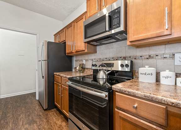 A kitchen with wooden cabinets and black appliances.