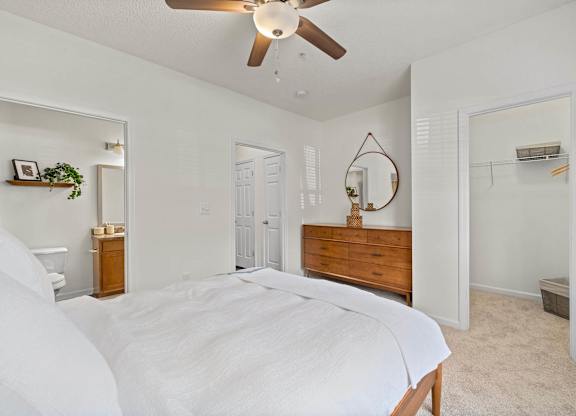 A bedroom with a large bed and a ceiling fan.