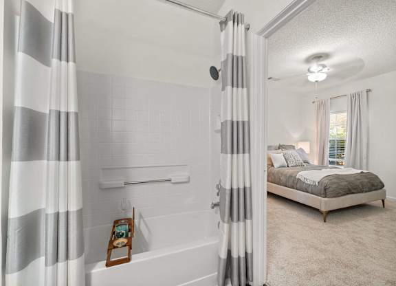 A bedroom with a bed, a window with curtains, and a picture frame on the window sill.