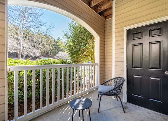 A black door is on the right side of a white fence.