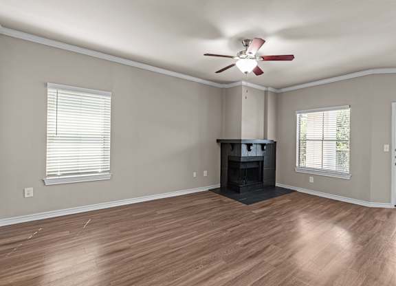 A room with a fireplace and a ceiling fan.