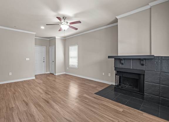 A living room with a fireplace and a ceiling fan.