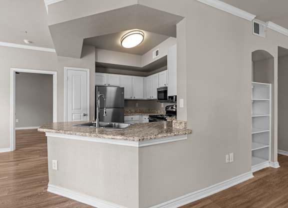 A kitchen with a granite countertop and a sink.