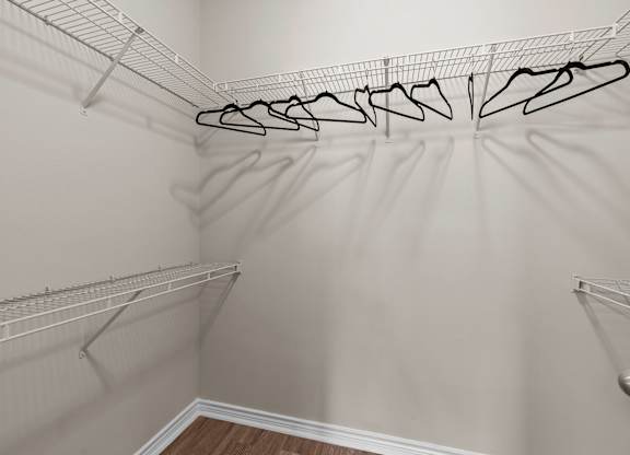 A white closet with clothes hangers.