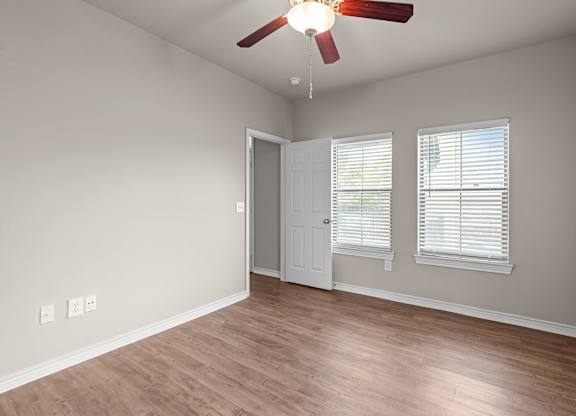 A room with a ceiling fan and a door.