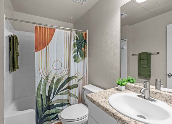 A bathroom with a toilet, sink, and shower curtain.