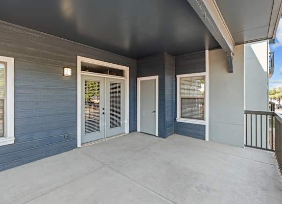 A balcony with a railing and a couple of doors.