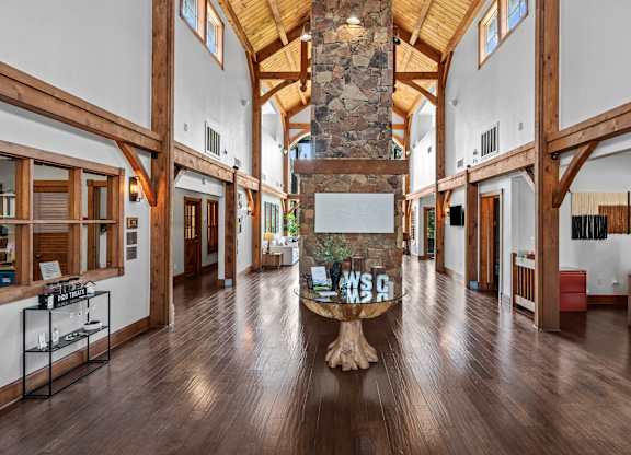 A large room with wooden floors and a stone pillar in the middle.
