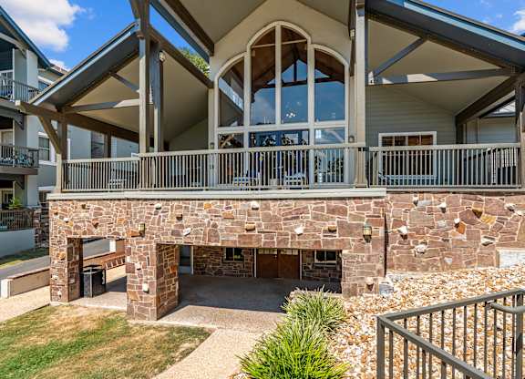 A house with a stone wall and a balcony.