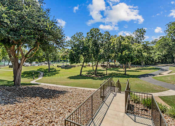 A staircase with a metal railing leads up to a grassy area.