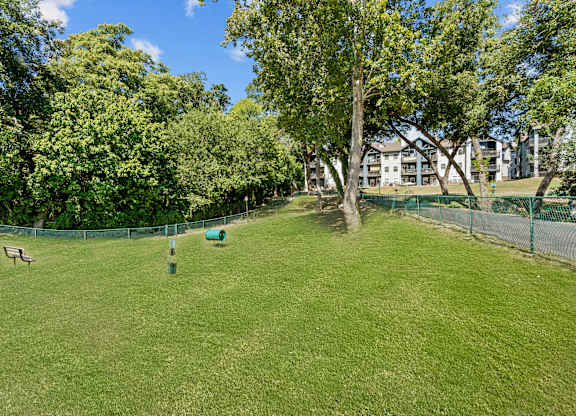 A park with a green lawn and trees.