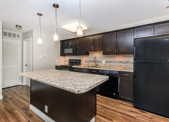 a kitchen with a large island with granite countertops