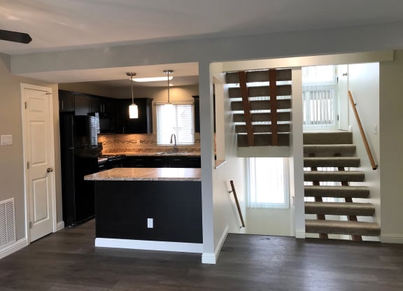 a kitchen with an island and stairs in a house