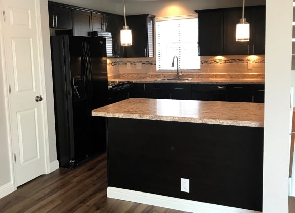 a kitchen with black cabinets and a counter top