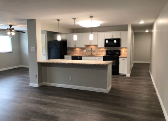 a kitchen with a counter top and a black refrigerator