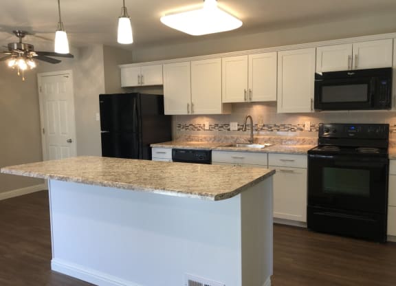 a kitchen with black appliances and a granite counter top