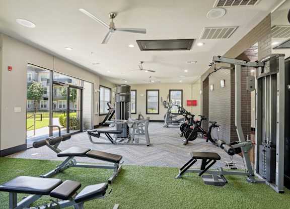 A gym with a variety of equipment including weights and cardio machines.