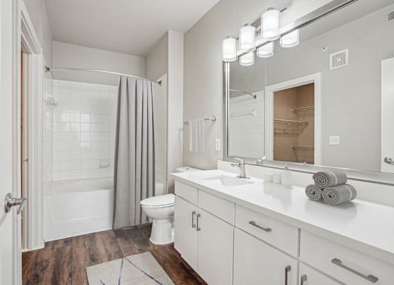 Bathroom with white vanity and tub shower at Highline Urban Lofts Apartments, Cypress, TX 77429