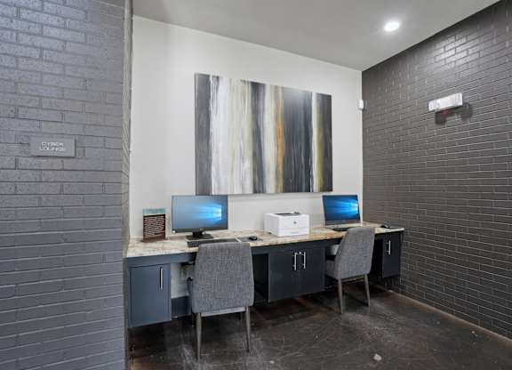 A room with a desk and two computers.