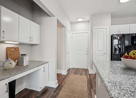 Galley kitchen with granite counters and white cabinetry at Highline Urban Lofts Apartments, Cypress