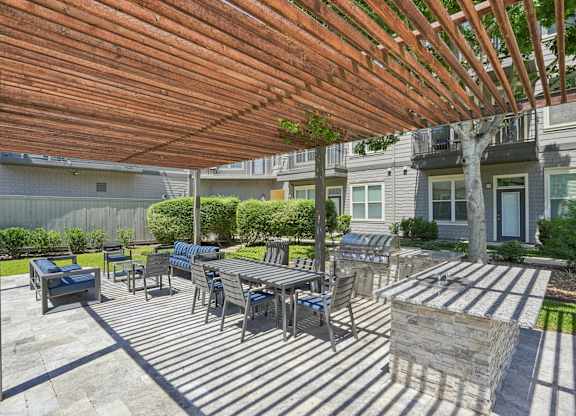Outdoor grilling patio with dining area and pergola at Highline Urban Lofts Apartments, Cypress, TX 77429