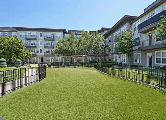 Courtyard with pet area and black fencing at Highline Urban Lofts Apartments, Texas