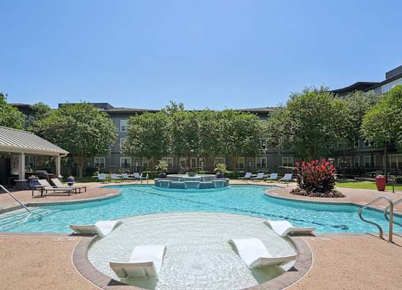 Poolside tanning shelf with lounge chairs and spa at Highline Urban Lofts Apartments, Texas