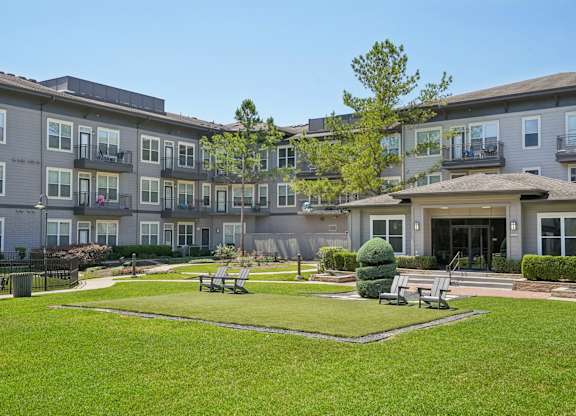 Central courtyard with lawn seating and bocce court at Highline Urban Lofts Apartments, Cypress, TX 77429