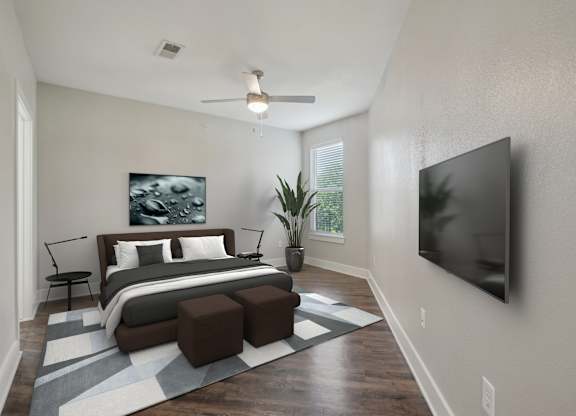 Modern bedroom with mounted tv and wood flooring at Highline Urban Lofts Apartments, Cypress, TX