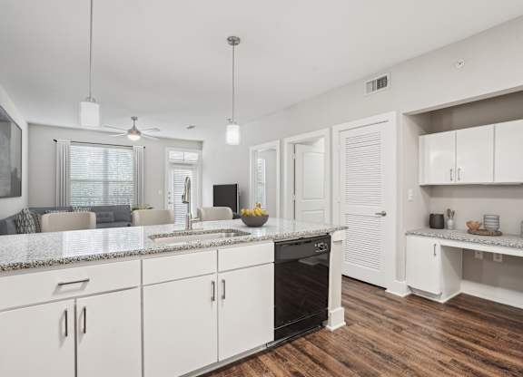 White kitchen with granite countertops and open layout at Highline Urban Lofts Apartments, Cypress, Texas