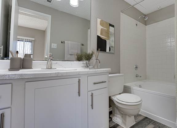 Bathroom with tub shower combo and white cabinetry at Carmel Creekside Apartments, Fort Worth, TX 76137