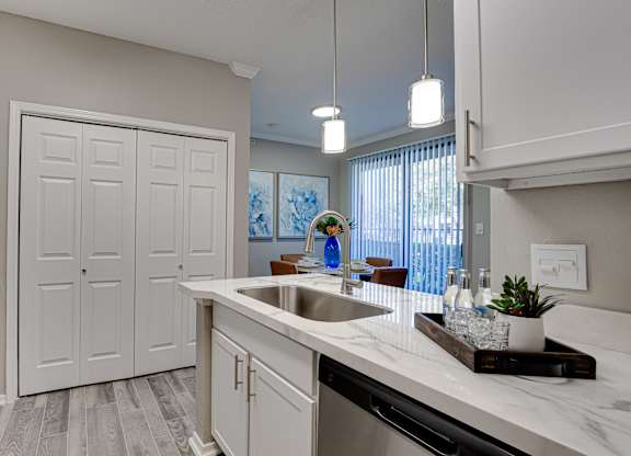 Kitchen island with sink and modern finishes at Carmel Creekside Apartments, Fort Worth, TX 76137
