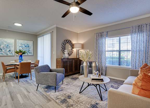 Living and dining room with decorative mirror at Carmel Creekside Apartments, Texas