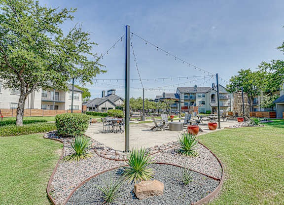 Outdoor courtyard with string lights and lounge seating at Carmel Creekside Apartments, Fort Worth, TX