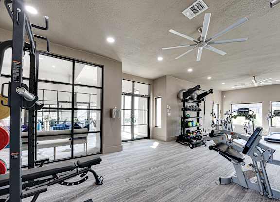 Fitness center with equipment rack and ceiling fan at Carmel Creekside Apartments, Fort Worth