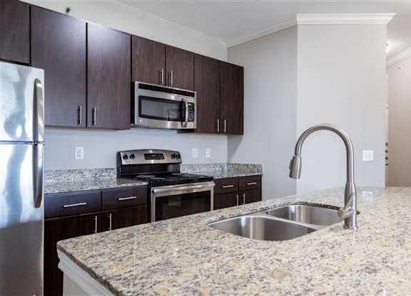 A kitchen with granite countertops and stainless steel appliances.